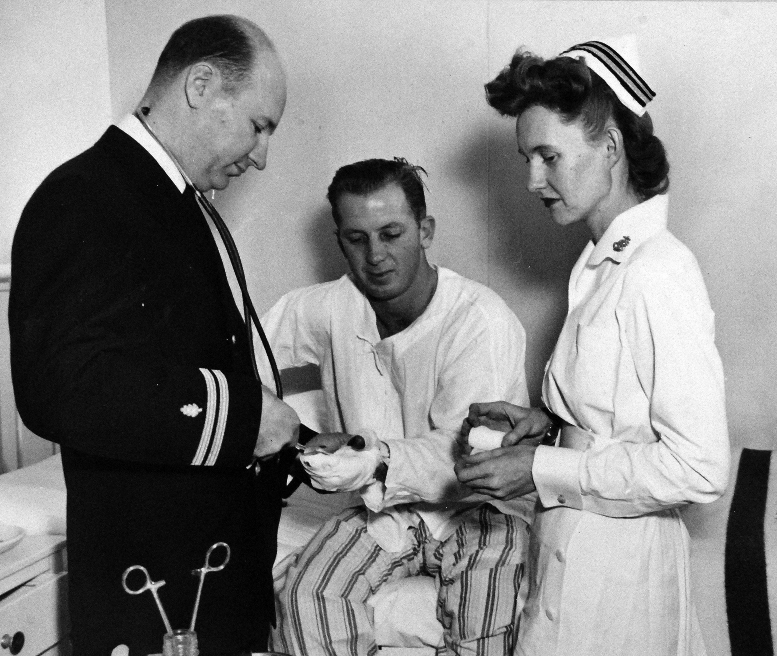 Navy Nurse Assists with Dressing Patient's Hand