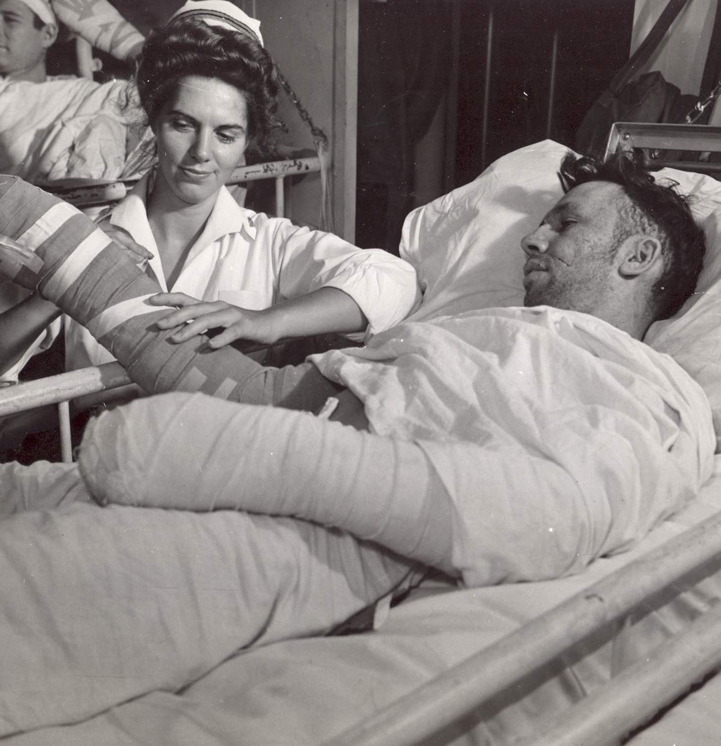 Navy Nurse Taping Cast of Wounded Sailor
